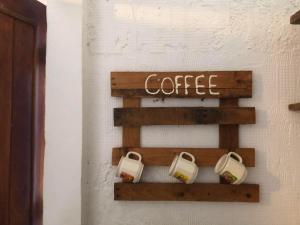 a shelf with coffee cups on a wall at El bungaló in Tecolutla