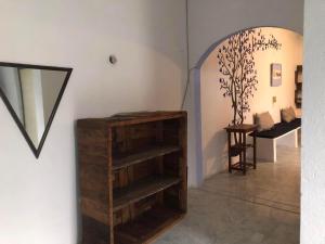 a room with a wooden book shelf and a table at El bungaló in Tecolutla