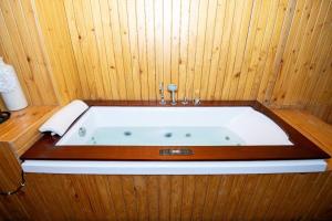 a bath tub in a room with wooden walls at Hotel Global in Bhatha