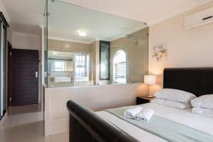 a bedroom with a bed and a large mirror at La Mustique 4 in Ballito