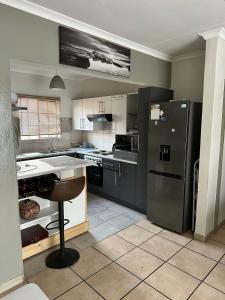 a kitchen with a refrigerator and a table in it at Ankazimia House at Reeds View in Roodepoort