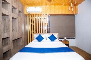 a bedroom with a large bed with blue pillows at Hotel Global in Bhatha
