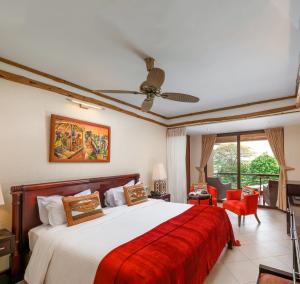 a bedroom with a bed and a ceiling fan at Chobe Safari Lodge in Kamdini