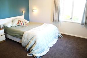 a bedroom with a bed with a pillow and a window at Lush, eco, family retreat in Tauranga +2 photos