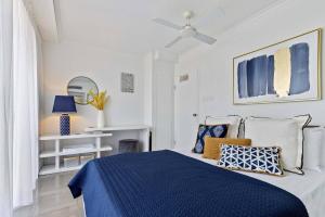 ケアンズにあるThe Abbott—A Sea-Swept Esplanade Abodeの白いベッドルーム(枕付きの青いベッド1台付)