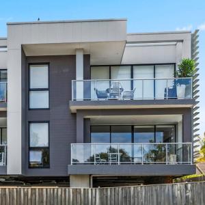 a house with a balcony with two chairs on it at Addison's Escape - A Breezy Beachfront Beauty in Shellharbour