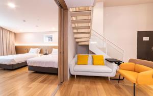 a hotel room with two beds and a staircase at New Seoul Hotel Myeongdong in Seoul