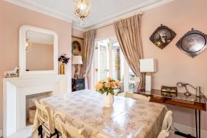 a dining room with a table and a vase of flowers at Designer's Town House in Winchester