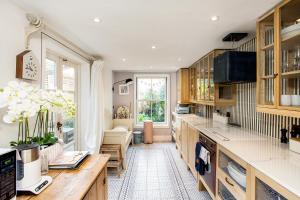 a kitchen with wooden cabinets and a large window at Designer's Town House in Winchester