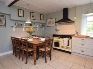 een keuken met een tafel en stoelen en een fornuis bij 3 Bed in Langport 75576 in Curry Rivel