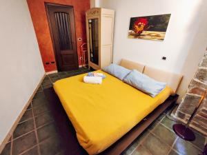a bed in a room with a yellow blanket at [Casa Glicine] Centro Storico in Pinerolo