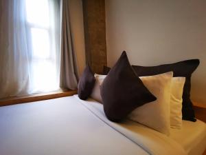 uma cama com almofadas pretas e brancas e uma janela em Urban Boutique Hotel em Boracay