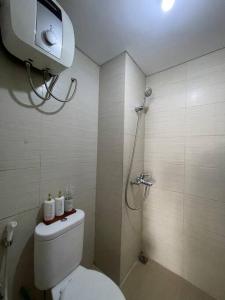 a bathroom with a shower with a toilet and a shower at Cozy Apartment 2 bedroom Gateway pasteur Bandung in Bandung +15 photos