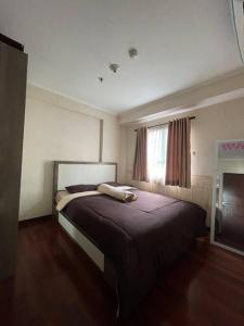 een slaapkamer met een groot bed voor een raam bij Cozy Apartment 2 bedroom Gateway pasteur Bandung in Bandung