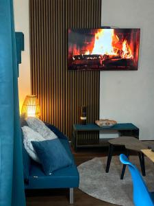a living room with a fireplace and a blue couch at Chionodoxa Places in Camigliatello Silano