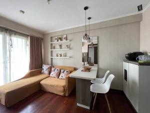 a bedroom with a bed and a table and a desk at Cozy Apartment 2 bedroom Gateway pasteur Bandung in Bandung