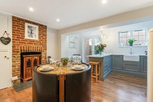 a kitchen and dining room with a table and a fireplace at Westgate Cottage A cosy city centre cottage with private rear garden in Winchester