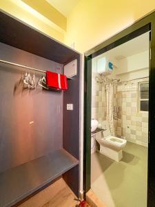 a bathroom with a toilet and a red purse at Irroi Guwahati in Guwahati
