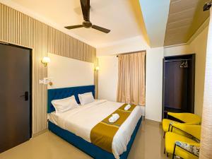 a bedroom with a large bed and a yellow chair at Irroi Guwahati in Guwahati