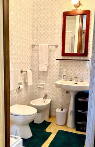 uma casa de banho com um WC, um lavatório e um espelho. em Chionodoxa Places em Camigliatello Silano