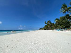 a white beach with palm trees and the ocean at Urban Boutique Hotel in Boracay