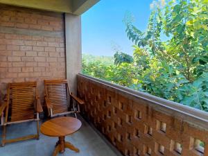 two chairs and a table on a balcony with a view at AMARA AYURVEDA RETREAT- Overlooking Evergreen Western Ghats an ecologically sustainable living space in Kovalam in Kovalam