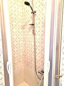 a shower in a bathroom with a tile wall at Chionodoxa Places in Camigliatello Silano