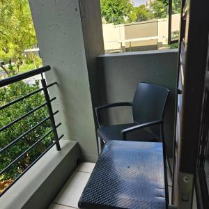a chair and a table on a balcony at Premium Apartment In Fourways in Sandton