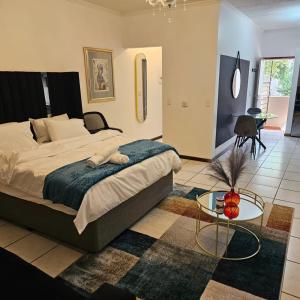a bedroom with a large bed and a table at Premium Apartment In Fourways in Sandton