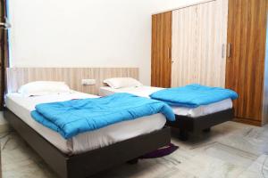 twee bedden in een kamer met blauwe dekens bij S.V Guest House in Pedda Ambarpet