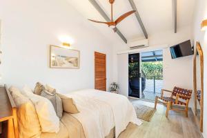 a bedroom with a bed and a tv and a chair at 'Villa Nalu' A Dreamy Fannie Bay Escape in Fannie Bay