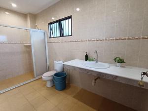 ein Bad mit einem Waschbecken, einem WC und einer Dusche in der Unterkunft Meranti Homestay in Bentong
