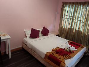 a bedroom with a bed with a table and a window at Meranti Homestay in Bentong