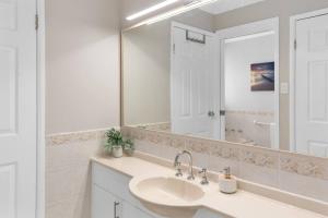 a white bathroom with a sink and a mirror at 'Pineview Escape' Generous Comfort for Families in Shellharbour +36 photos