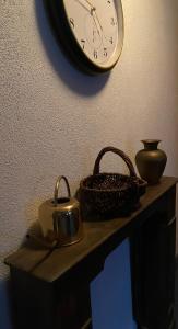 eine Uhr an einer Wand über einem Tisch mit einem Wasserkocher und einem Korb in der Unterkunft Gasthof Rössle Eberhardzell in Füramoos
