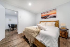 1 dormitorio con 1 cama grande y una pintura en la pared en Sand and Serenity en Henley Beach South