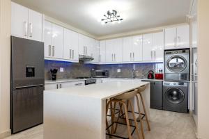 a kitchen with white cabinets and stainless steel appliances at Shanthi Apartment 8 in Ballito
