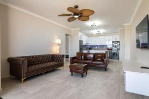 uma sala de estar com 2 sofás e uma ventoinha de tecto em Shanthi Apartment 8 em Ballito