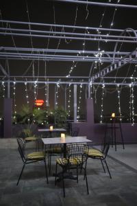 a patio with a table and chairs and lights at Irroi Guwahati in Guwahati