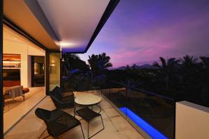 ポートダグラスにある61 Murphy Street—A Poolside Villa for Fourの家のバルコニー(テーブル、椅子付)
