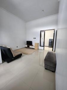 Il comprend un salon blanc doté d'un canapé et d'une télévision. dans l'établissement Villa Jingga Joyogrand Malang, à Malang