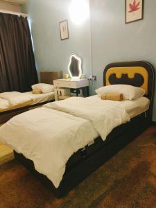 - une chambre avec 2 lits et un miroir mural dans l'établissement LUNAS DIY HOMESTAY, à Lunas