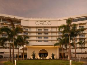 an oroc hotel with palm trees in front of it at Ardo in Townsville
