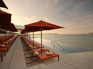 a row of tables and umbrellas next to a pool at Ardo in Townsville