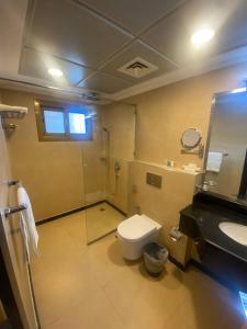 een badkamer met een toilet, een douche en een wastafel bij Nooh Apartment in Al Ḩadd