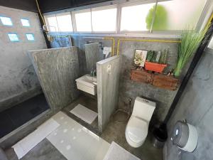 a small bathroom with a toilet and a sink at ลอดจ์พังงา บูทีค in Phangnga