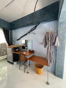 um quarto com uma secretária e um casaco pendurado numa parede em ลอดจ์พังงา บูทีค em Phangnga