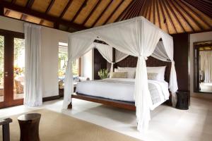 a bedroom with a bed with a canopy at The Ungasan Clifftop Resort in Uluwatu