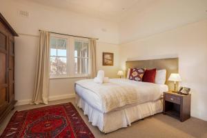 a bedroom with a large bed and a window at Reset your Senses in Meroo at Lone Pine Farmhouse in Windeyer