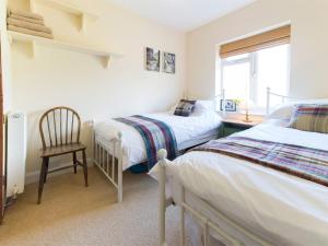 a bedroom with two beds and a chair and a window at 3 bed property in Harrogate District HH057 in Harrogate
